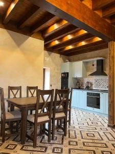 a kitchen with a wooden table and chairs at CASA RURAL EL TORREON in Fontiveros