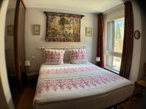 a bedroom with a bed with a painting on the wall at L'Outa Panoramique in Chamonix