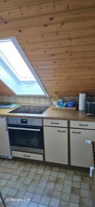 a kitchen with a stove and a skylight at Ferienwohnung mit Kreuzbergblick in Bischofsheim an der Rhön +11 photos