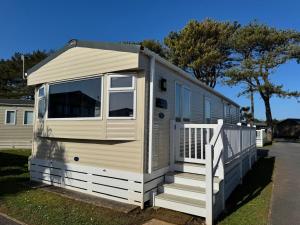 a tiny house with a porch and a staircase at Captain's Cabin - Brixham - with designated parking in Brixham