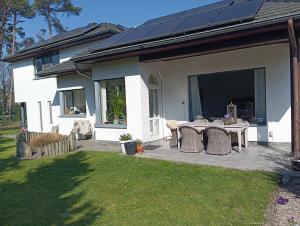 a house with a patio with a table in the yard at logies Huis Liselotte in Genk