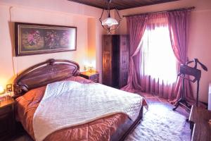 a bedroom with a large bed and a window at Archontiko Velousi in Pantévgeni