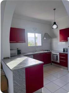 a kitchen with red cabinets and a counter top at Villa lina in Midoun