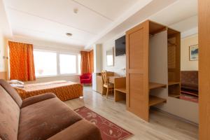 a hotel room with a bed and a desk at Carolina Hotel in Pärnu