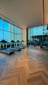 a gym with a row of benches in a room with windows at Sorici Studio at Bella Tower in Surabaya