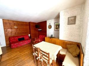 ein Wohnzimmer mit einem Tisch und einem roten Sofa in der Unterkunft Piccolo Bric in Ghigo
