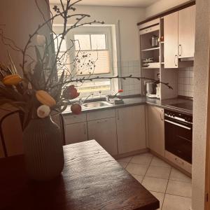 a kitchen with a vase of flowers on a table at Ferienwohnung Schwarzwaldrand in Nagold