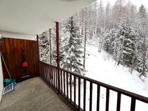 ein Balkon mit Blick auf einen schneebedeckten Wald in der Unterkunft Piccolo Bric in Ghigo