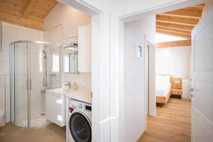 a bathroom with a shower and a washing machine at Tyrolschalet LITTLE LUCK - Private Pool & Mountain View in Rofansiedlung
