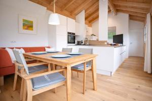 a kitchen and dining room with a wooden table and chairs at Tyrolschalet LITTLE LUCK - Private Pool & Mountain View in Rofansiedlung