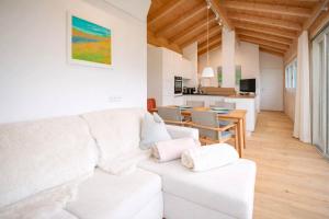 a white living room with a white couch and a table at Tyrolschalet LITTLE LUCK - Private Pool & Mountain View in Rofansiedlung