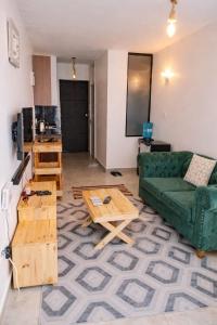 a living room with a green couch and coffee tables at Bohen BnB 1 in Ongata Rongai 