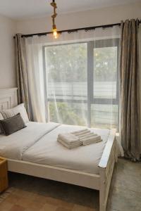 a bed in a bedroom with a large window at Bohen BnB 1 in Ongata Rongai 