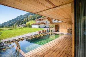 a house with a pool and a wooden deck at RACING Suite - Terrace & Sauna Access in Kleinboden
