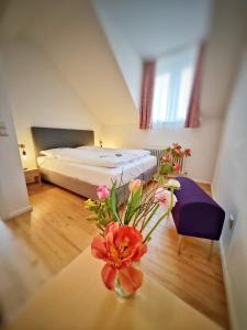 a bedroom with a bed and a table with flowers on it at Goethe Schwarzwald Boutiquehotel in Staufen im Breisgau +94 photos