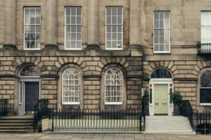 ein Gebäude mit einer grünen Tür und Treppe in der Unterkunft Lyla Rooms in Edinburgh