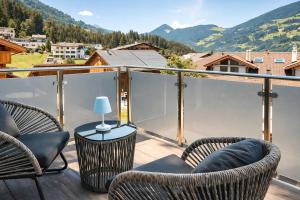 a balcony with chairs and a table with a view at CLOUD 9 - Private Whirlpool & Rooftop Terrace in Fügen +32 photos