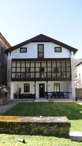 a large white building with windows and a yard at Casa Vizcaya, Casa rural para grupos de hasta 20 personas en Lanestosa, ideal para reuniones y celebraciones tranquilas in Lanestosa