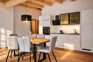 a kitchen with a wooden dining table and chairs at CHEZ NOUS - Balcony & Mountain View in Fügen +16 photos