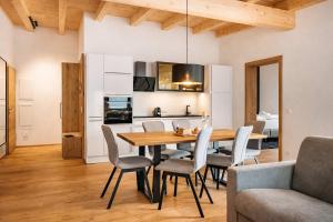 a kitchen and dining room with a wooden table and chairs at CHEZ NOUS - Balcony & Mountain View in Fügen