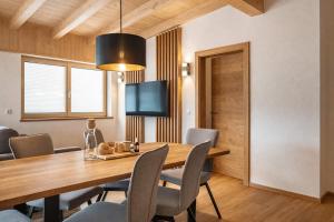 a dining room with a wooden table and chairs at CHEZ NOUS - Balcony & Mountain View in Fügen
