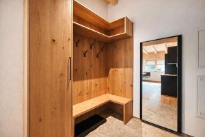 a room with a wooden wall with a mirror at ViVaZILARE - Design Loft with Terrace in Fügen +27 photos