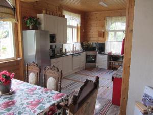 a kitchen with a table and a refrigerator at Willa Tapala in Matildedal +17 photos