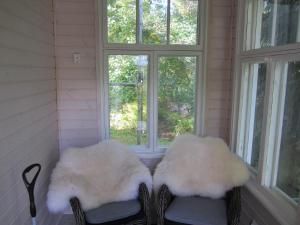 two chairs with white cushions sitting in front of windows at Willa Tapala in Matildedal