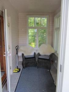 a room with two wicker chairs and a window at Willa Tapala in Matildedal