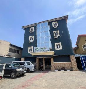 a blue building with cars parked in a parking lot at Oasis hotel and suites in Lagos