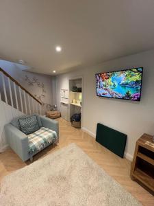 a living room with a tv hanging on the wall at Thistle Nook in Coldstream