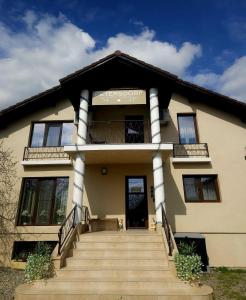 a building with a staircase in front of it at Vila Petersdorf in Petreşti