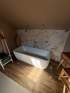 a white bath tub in a bathroom with a marble wall at Thistle Nook in Coldstream +21 photos