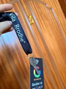 a person holding a tag with a key on a door at Vila Rrodhe in Durrës