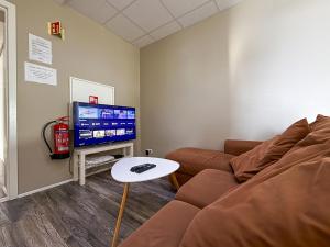 a living room with a couch and a tv at Við Hafið Oceanfront Guesthouse in Ólafsvík