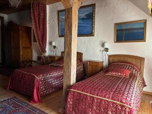a bedroom with two beds with red comforter at Kukšu muiža in Kukšas