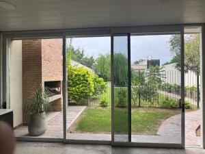 an open sliding glass door with a view of a yard at Attalia in Santiago del Estero