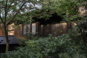 a house with a wooden fence in a garden at Bed and Craft in Nanto