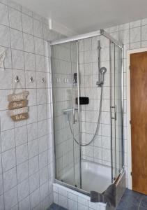 a shower with a glass door in a bathroom at Ostsee Pension Pohnsdorfer Mühle in Sierksdorf +38 photos