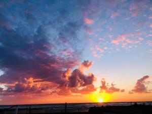 a sunset on the beach with a cloud formation at ALT alloggio turistico in Focene +2 photos