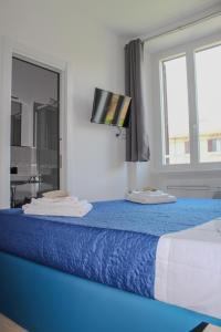a bedroom with a blue bed with a window at SunnyCornerinRHome in Rome