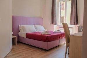 a bedroom with a purple bed with a table and a chair at SunnyCornerinRHome in Rome