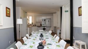 a long dining room with a long table and white chairs at Casa Vizcaya, Casa rural para grupos de hasta 20 personas en Lanestosa, ideal para reuniones y celebraciones tranquilas in Lanestosa