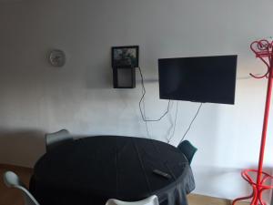 a black table with a tv on a wall at Le repos beaurepairien in Beaurepaire