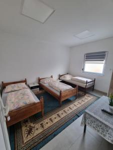 a room with two beds and a rug at Sobe Kod Ćobe in Matuzići +6 photos
