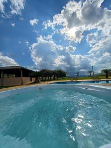 a large swimming pool with a cloudy sky in the background at Montinni Hotel in Socorro