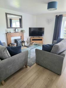 a living room with two couches and a glass table at 12 Ivy Cottage in St Ives