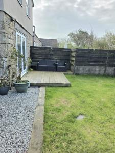 a garden with a black couch in a yard at 12 Ivy Cottage in St Ives