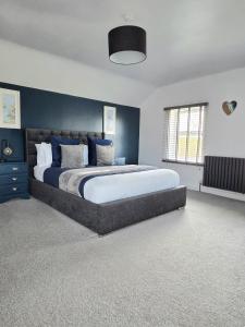 a bedroom with a large bed with blue walls at 12 Ivy Cottage in St Ives
