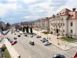 a city street with cars parked in a parking lot at La Mansardă in Câmpulung